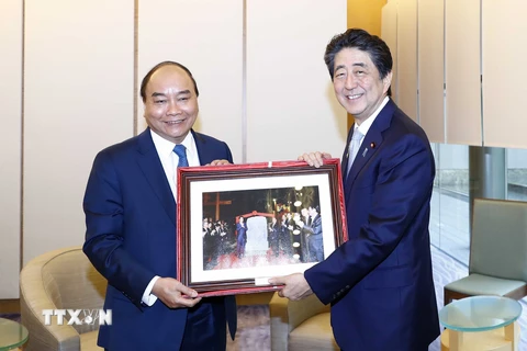 Thủ tướng Nguyễn Xuân Phúc tặng bức ảnh chụp chung với Thủ tướng Abe Shinzo tại Hội An (Quảng Nam) trong dịp ông Abe tham dự Hội nghị Cấp cao APEC năm 2017 (Tokyo, 1/7/2019). (Ảnh: Thống Nhất/TTXVN)