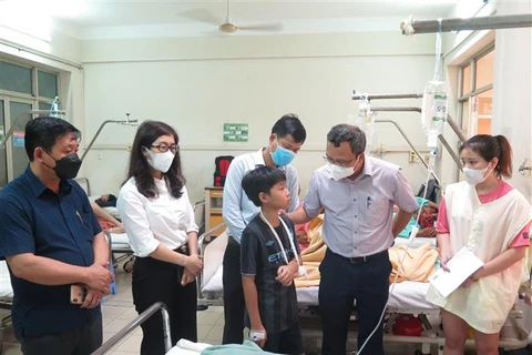 Ông Khuất Việt Hùng, Phó Chủ tịch chuyên trách Ủy ban An toàn giao thông Quốc gia (thứ hai, phải) thăm hỏi nạn nhân bị thương nặng đang nằm điều trị tại Bệnh viện Đa khoa tỉnh Khánh Hòa. (Ảnh: Phan Sáu/TTXVN)