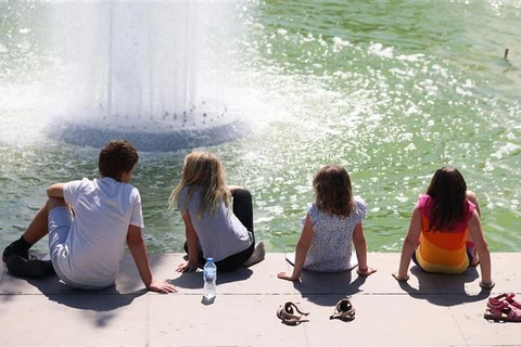 Trẻ em làm mát bên đài phun nước ở Trocadero khi nhiệt độ được cảnh báo có thể lên tới 39 độ ở thủ đô Paris (Pháp), ngày 16/6/2022. (Ảnh: THX/TTXVN)