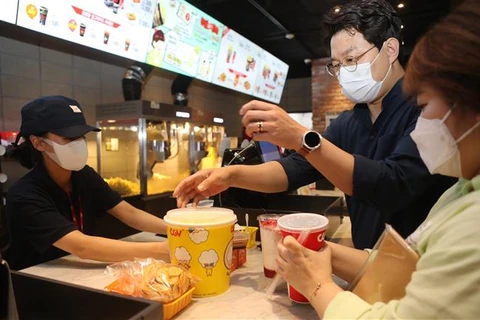Người dân mua đồ ăn trong một rạp chiếu phim ở Jeonju, tỉnh Bắc Jeolla (Hàn Quốc) ngày 25/4/2022, khi nước này chính thức hạ cấp độ dịch COVID-19. (Ảnh: Yonhap/TTXVN)