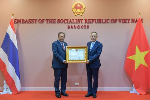 Đại sứ Việt Nam tại Thái Lan Phan Chí Thành (bên phải) trao tặng giấy khen cho ông Adisak Thepart (bên trái), nguyên Tỉnh trưởng tỉnh Nakhon Phanom. (Ảnh: Huy Tiến/PV TTXVN tại Thái Lan)