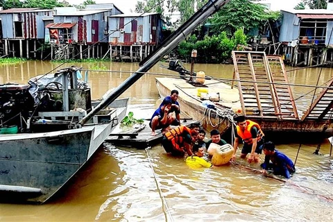 Cán bộ, chiến sỹ Đồn Biên phòng Vĩnh Gia trục vớt phương tiện và hàng hóa bị chìm trên kinh Vĩnh Tế. (Ảnh: TTXVN phát)