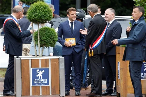 Tổng thống Pháp Emmanuel Macron (giữa) trao đổi với các quan chức khi ông tới bỏ phiếu bầu cử Quốc hội vòng hai tại Le Touquet, ngày 19/6/2022. (Ảnh: AFP/TTXVN)