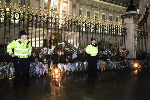 Người dân đặt hoa và nến tưởng niệm dọc theo hàng dào bảo vê bên ngoài Cung điện Buckingham. Ảnh: Hải Vân - PV TTXVN tại Vương quốc Anh