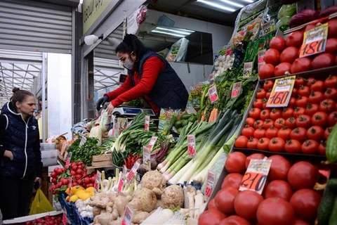 Khách hàng mua rau củ quả tại một chợ ở Moskva (Nga). (Ảnh: AFP/TTXVN)
