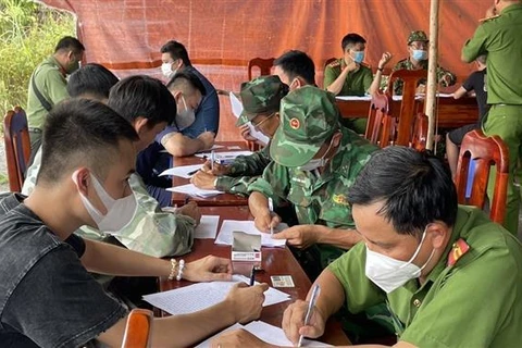 Bộ đội Biên phòng và Công an tỉnh Tây Ninh làm các thủ tục tiếp nhận người lao động tự do tại Campuchia trở về nước. (Ảnh: TTXVN phát)