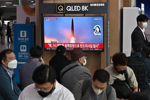 Người dân theo dõi vụ phóng tên lửa của Triều Tiên được phát trên truyền hình Hàn Quốc tại một nhà ga ở Seoul, ngày 4/10/2022. (Ảnh: AFP/TTXVN)