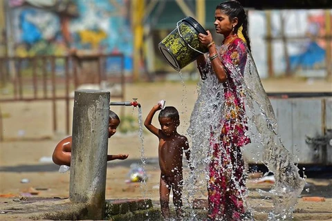 Người dân giải nhiệt tại một vòi nước công cộng trong thời tiết nắng nóng tại Allahabad (Ấn Độ), ngày 28/4/2022. (Ảnh: AFP/TTXVN)
