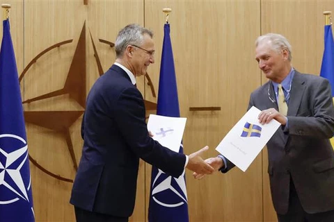 Tổng Thư ký Tổ chức Hiệp ước Bắc Đại Tây Dương (NATO) Jens Stoltenberg (trái) tiếp nhận đơn xin gia nhập liên minh quân sự từ đại sứ Thụy Điển tại NATO Axel Wernhoff ở Brussels (Bỉ), ngày 18/5/2022. (Ảnh: AFP/TTXVN)