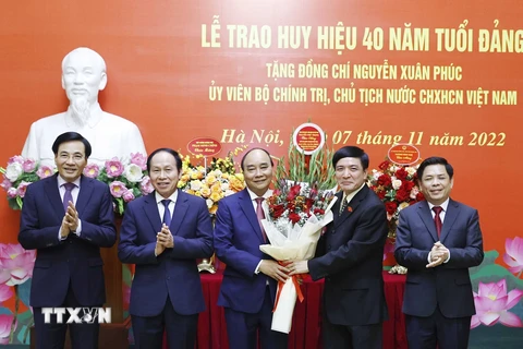 Các lãnh đạo tặng hoa Chủ tịch nước Nguyễn Xuân Phúc. (Ảnh: Thống Nhất/TTXVN)