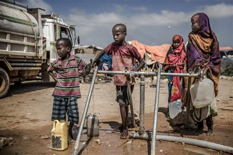 Trẻ em chờ lấy nước tại vòi nước công cộng ở Beledweyne (Somalia). (Ảnh: AFP/TTXVN)