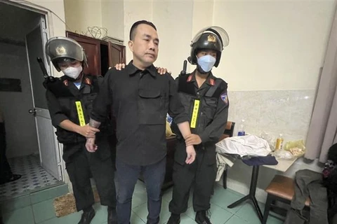 Lực lượng công an bắt giữ và khám xét nơi ở trọ của Lê Thanh Tuấn. (Ảnh: TTXVN phát)