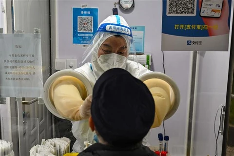 Nhân viên y tế lấy mẫu xét nghiệm COVID-19 cho người dân tại Thượng Hải (Trung Quốc), ngày 7/12/2022. (Ảnh: AFP/TTXVN)