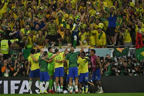 Các tuyển thủ Brazil chia vui với cổ động viên sau chiến thắng 4-1 trước đội tuyển Hàn Quốc trên sân Doha (Qatar) ngày 5/12/2022. (Ảnh: AFP/TTXVN)