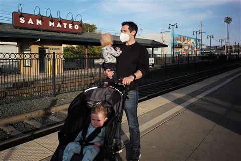 Người dân đeo khẩu trang phòng dịch COVID-19 tại ga tàu hỏa ở San Mateo, bang California (Mỹ) hồi năm ngoái. (Ảnh: THX/TTXVN)