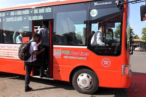 Hành khách lên xe buýt trong ngày khai trương tuyến xe buýt liền kề kết nối Đồng Nai-Thành phố Hồ Chí Minh. (Ảnh: Nguyễn Văn Việt/TTXVN)