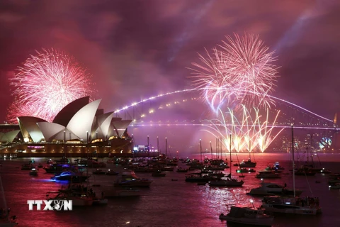 Màn pháo hoa rực rỡ sắc màu đón Năm mới 2023 tại cầu cảng ở thành phố Sydney (Australia). (Ảnh: AFP/TTXVN)