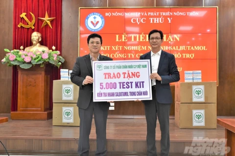 Ông Nguyễn Văn Long - đại diện Cục Thú y (trái) tiếp nhận 5.000 kit xét nghiệm nhanh Salbutamol do Công ty Cổ phần Chăn nuôi C.P. Việt Nam hỗ trợ. (Ảnh: Phạm Hiếu)