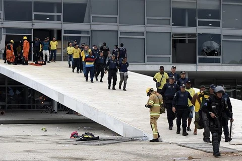 Lực lượng an ninh bắt giữ các đối tượng biểu tình đột nhập vào Dinh Tổng thống tại Brasilia ngày 8/1/2023. (Ảnh: AFP/TTXVN)