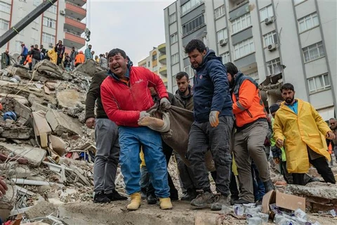 Lực lượng cứu hộ chuyển thi thể nạn nhân tại hiện trường đổ nát sau trận động đất ở Adana (Thổ Nhĩ Kỳ) ngày 6/2/2023. (Ảnh: AFP/TTXVN)