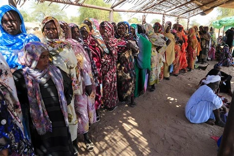 Phụ nữ Sudan chờ nhận hàng cứu trợ tại trại tị nạn dành cho những người mất nhà cửa do chiến tranh ở Nyala, Nam Darfur. (Ảnh: AFP/TTXVN)