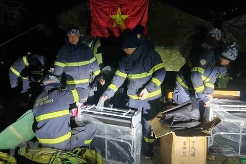 Đoàn công tác dựng lều chuẩn bị cho công tác cứu hộ. (Ảnh: TTXVN phát)