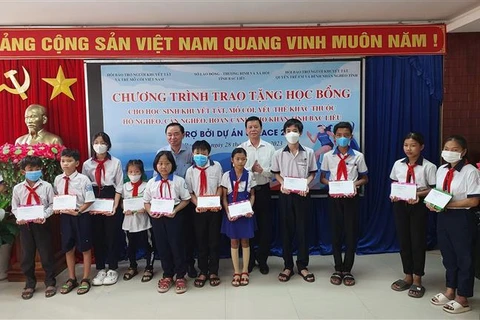 Ông Nguyễn Trọng Đàm - Chủ tịch Hội Bảo tuy Người Khuyết tật và Trẻ em mồ côi Việt Nam và ông Phan Thanh Duy - Phó Chủ tịch Ủy ban Nhân dân tỉnh Bạc Liêu trao học bổng tại chương trình. (Ảnh: Tuấn Kiệt/TTXVN)