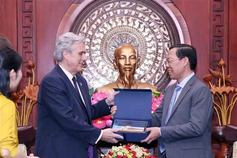 Chủ tịch Ủy ban Nhân dân Thành phố Hồ Chí Minh Phan Văn Mãi (phải) tặng quà lưu niệm cho ông Mark Garnier (trái), Đặc phái viên của Thủ tướng Anh về thương mại tại Thái Lan, Myanmar, Brunei và Việt Nam. (Ảnh: Xuân Khu/TTXVN)