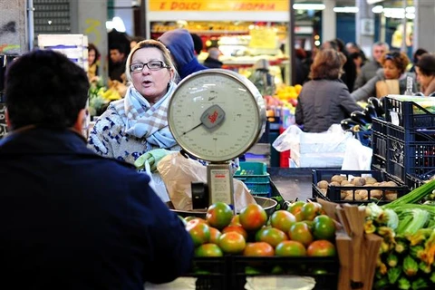 Người dân mua thực phẩm tại một khu chợ ở Rome (Italy). (Ảnh: AFP/TTXVN)