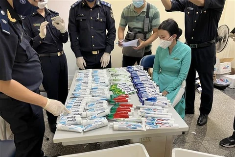 Kiểm đếm lô hàng chất ma túy được giấu trong những tuýp kem đánh răng bị thu giữ từ hành lý của 4 tiếp viên hàng không. Ảnh: TTXVN phát