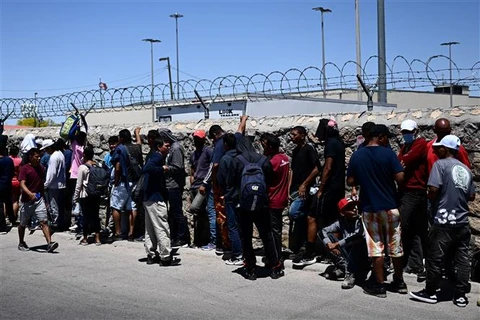 Người di cư chờ xét duyệt bên ngoài Cơ quan kiểm soát biên phòng Mỹ, sau khi vượt qua biên giới Mexico vào El Paso, bang Texas (Mỹ), ngày 9/5/2023. (Ảnh: AFP/TTXVN)