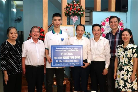 Phó Chủ tịch Ủy ban Nhân dân tỉnh Hà Giang Trần Đức Quý trao thưởng cho em Hoàng Tuấn Dũng. (Ảnh: Minh Tâm/TTXVN)