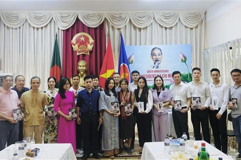 Lãnh đạo Đại sứ quán Việt Nam tại Bangladesh trao tặng bà con Việt Nam các tác phẩm về Bác. (Ảnh: TTXVN phát)