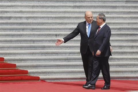 Thủ tướng Trung Quốc Lý Cường (phải) và Thủ tướng Nga Mikhail Mishustin tại lễ đón ở Bắc Kinh ngày 24/5/2023. (Ảnh: Kyodo/TTXVN)