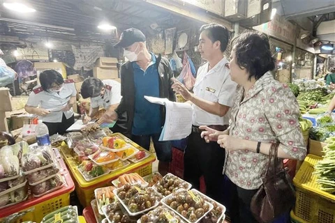 Đoàn Kiểm tra Ban Quản lý an toàn thực phẩm Thành phố Hồ Chí Minh kiểm tra rau củ quả tại chợ đầu mối nông sản Thủ Đức. (Ảnh: TTXVN phát)
