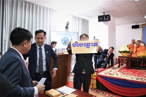 Các quan chức và nhân viên Ủy ban Bầu cử Quốc gia Campuchia giới thiệu thùng phiếu tại lễ bốc thăm. (Ảnh: Huỳnh Thảo/TTXVN)