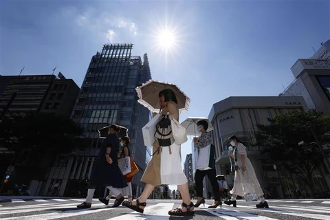 Người dân di chuyển dưới tiết trời nắng nóng tại Nagoya (Nhật Bản). (Ảnh: Kyodo/TTXVN)
