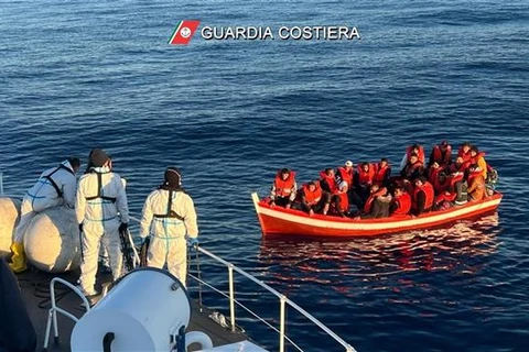 Lực lượng Bảo vệ Bờ biển Italy (trái) giải cứu những người di cư trên Địa Trung Hải ngày 10/4/2023. (Ảnh: AFP/TTXVN)