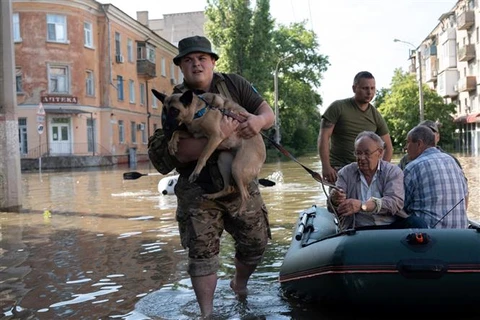 Quân đội hỗ trợ người dân sơ tán khỏi khu vực ngập lụt sau vụ vỡ đập thủy điện Kakhovka tại tỉnh Kherson, miền Nam Ukraine, ngày 7/6/2023. (Ảnh: AFP/TTXVN)
