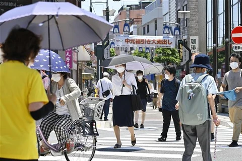 Người dân di chuyển dưới tiết trời nắng nóng tại Tokyo (Nhật Bản). (Ảnh: Kyodo/TTXVN)