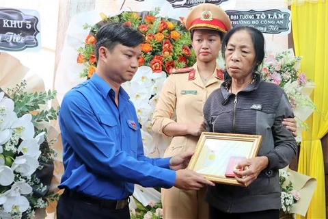 Trung ương Đoàn truy tặng Huy hiệu "Tuổi trẻ dũng cảm" cho liệt sỹ, Thiếu tá Trần Quốc Thắng đến gia đình chiến sỹ. (Ảnh: Hoài Thu/TTXVN)