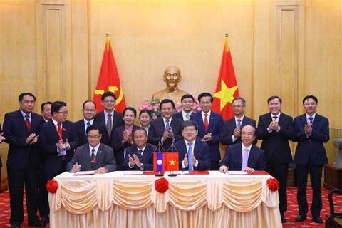Lễ ký Biên bản ghi nhớ hợp tác giữa bốn cơ quan của Việt Nam và Lào. (Ảnh: Văn Điệp/TTXVN)