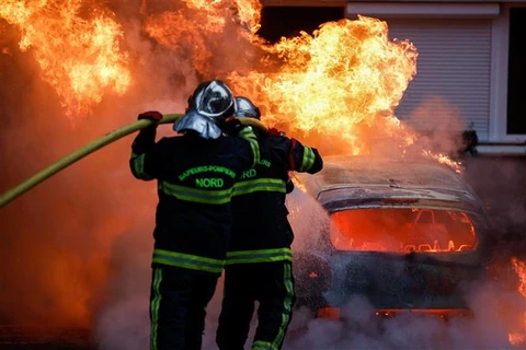 Lính cứu hoả dập lửa một phương tiện bị người biểu tình phóng hoả tại Lille, miền Đông Pháp ngày 29/6/2023. (Ảnh: AFP/TTXVN)