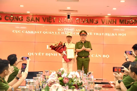 Thượng tá Nguyễn Thành Vĩnh - Tân Giám đốc Trung tâm Dữ liệu Quốc gia về Dân cư (trái) nhận quyết định bổ nhiệm từ Cục trưởng C06 Nguyễn Quốc Hùng. (Nguồn: Lao Động)