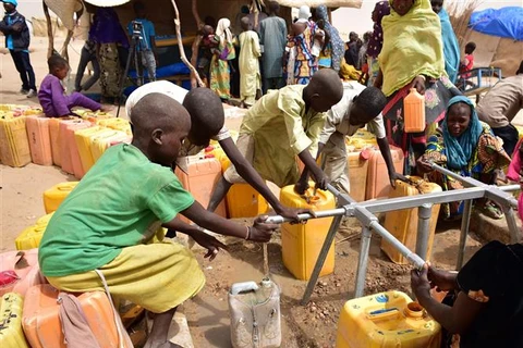 Trẻ em lấy nước tại vòi nước công cộng trong trại tị nạn ở Kidjendi, Đông Nam Niger. (Ảnh: AFP/TTXVN)