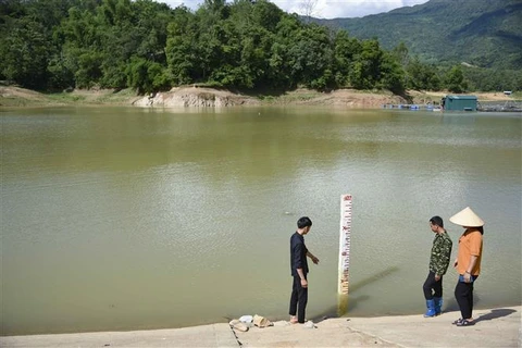 Công nhân Công ty Trách nhiệm Hữu hạn Quản lý Thủy Nông Điện Biên kiểm tra mực nước tại hồ Hồng Sạt. (Ảnh: Xuân Tư/TTXVN)