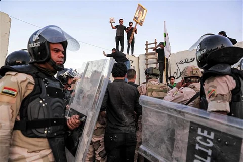 Cảnh sát chống bạo động Iraq giải tán đám đông biểu tình bên ngoài Đại sứ quán Thụy Điển tại Thủ đô Baghdad, ngày 20/7/2023. (Ảnh: AFP/TTXVN)