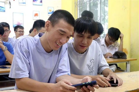 Em Nguyễn Mạnh Hùng (trái) và em Đặng Tuấn Anh xem điểm thi Kỳ thi Tốt nghiệp Trung học Phổ thông năm 2023. (Ảnh: Đinh Văn Nhiều/TTXVN)