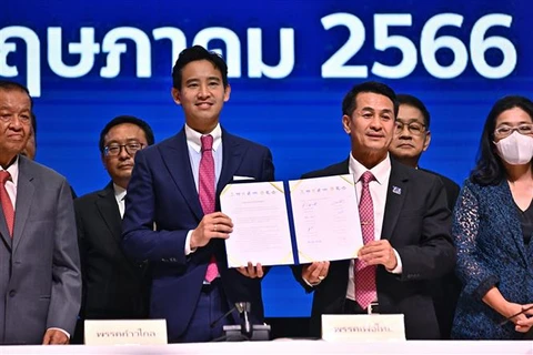 Lãnh đạo đảng Tiến bước của Thái Lan Pita Limjaroenrat (giữa, trái) và lãnh đạo đảng Vì nước Thái Cholanan Srikaew (giữa, phải) tại lễ ký Bản ghi nhớ về thể thức thành lập Chính phủ mới, tại Bangkok, ngày 22/5/2023. (Ảnh: AFP/TTXVN)