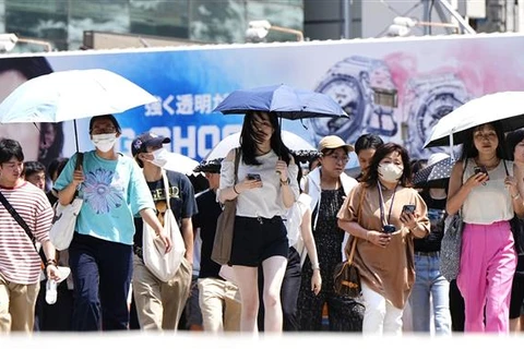 Người dân Tokyo (Nhật Bản) di chuyển dưới trời nắng nóng, ngày 27/7/2023. (Ảnh: Kyodo/TTXVN)